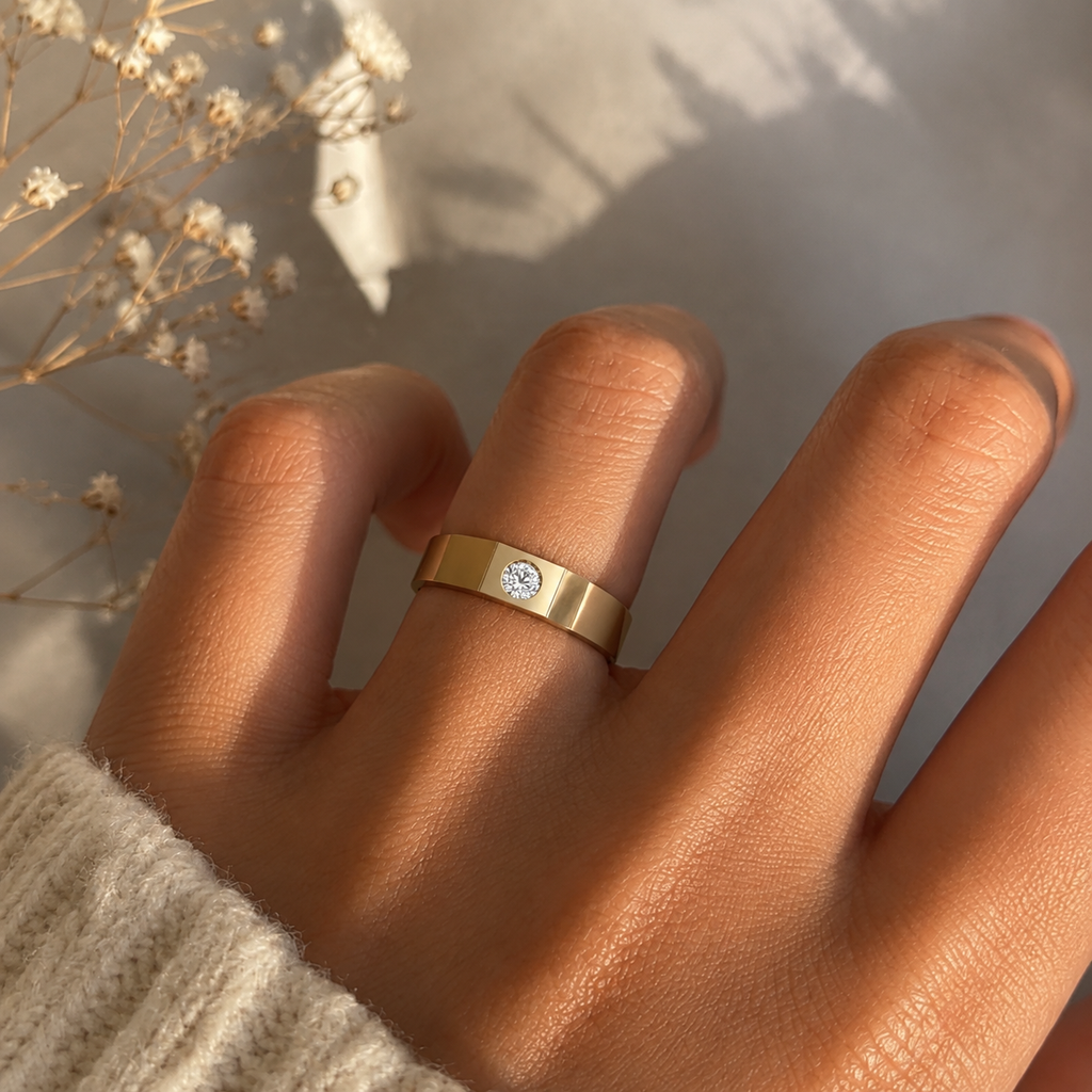 Two-tone bezel solitaire band ring worn on hand in warm sunlight